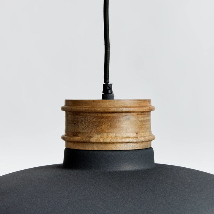 Detail of pendant light’s iron and mango wood connection point, blending rustic tone with minimalist form – modern organic style.