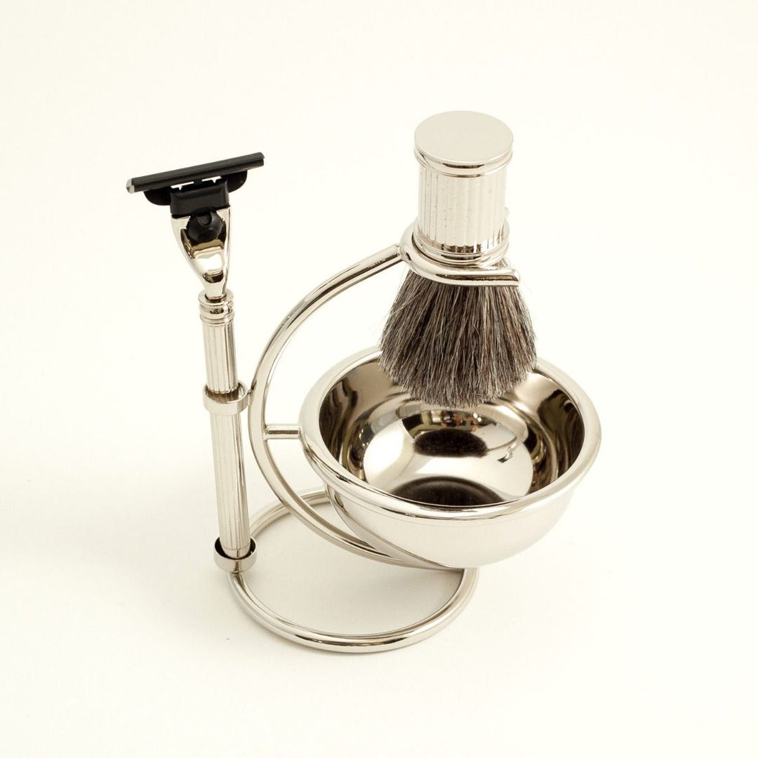Top view of chrome razor and pure badger brush four-piece shave set with bowl and stand, tarnish-resistant metal finish.