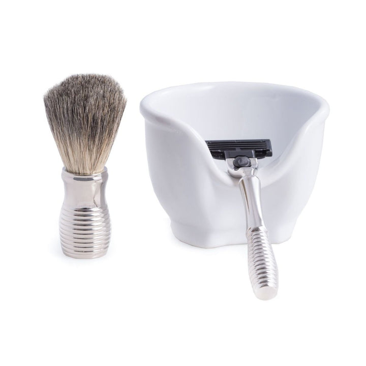 Shaving brush, shaving bowl, and razor on a white background