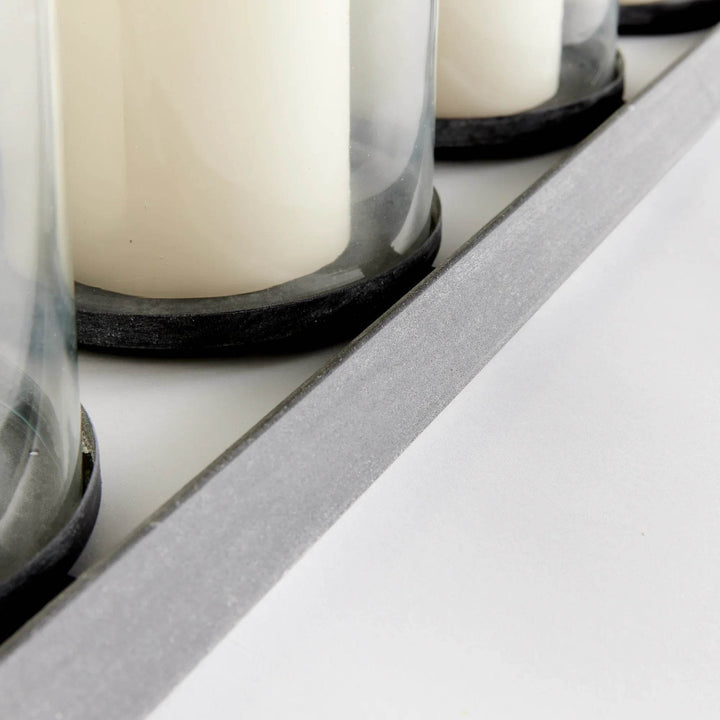 Close-up of clear glass candle cylinder and aged zinc frame detail – Modern Industrial.