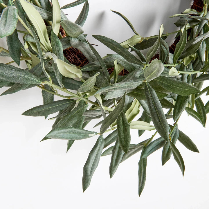 Close-up of lifelike olive leaves and twigs on rustic farmhouse wreath

