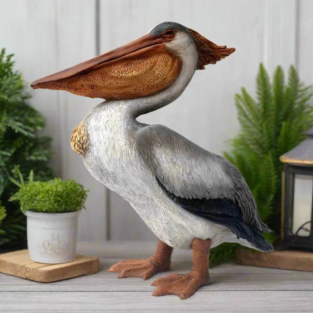 Coastal pelican statue displayed indoors with plants and lantern for beach-inspired decor