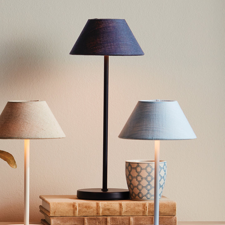 Dark blue and light blue cordless LED table lamps with linen empire shades styled in a layered interior setting – Coastal Transitional
