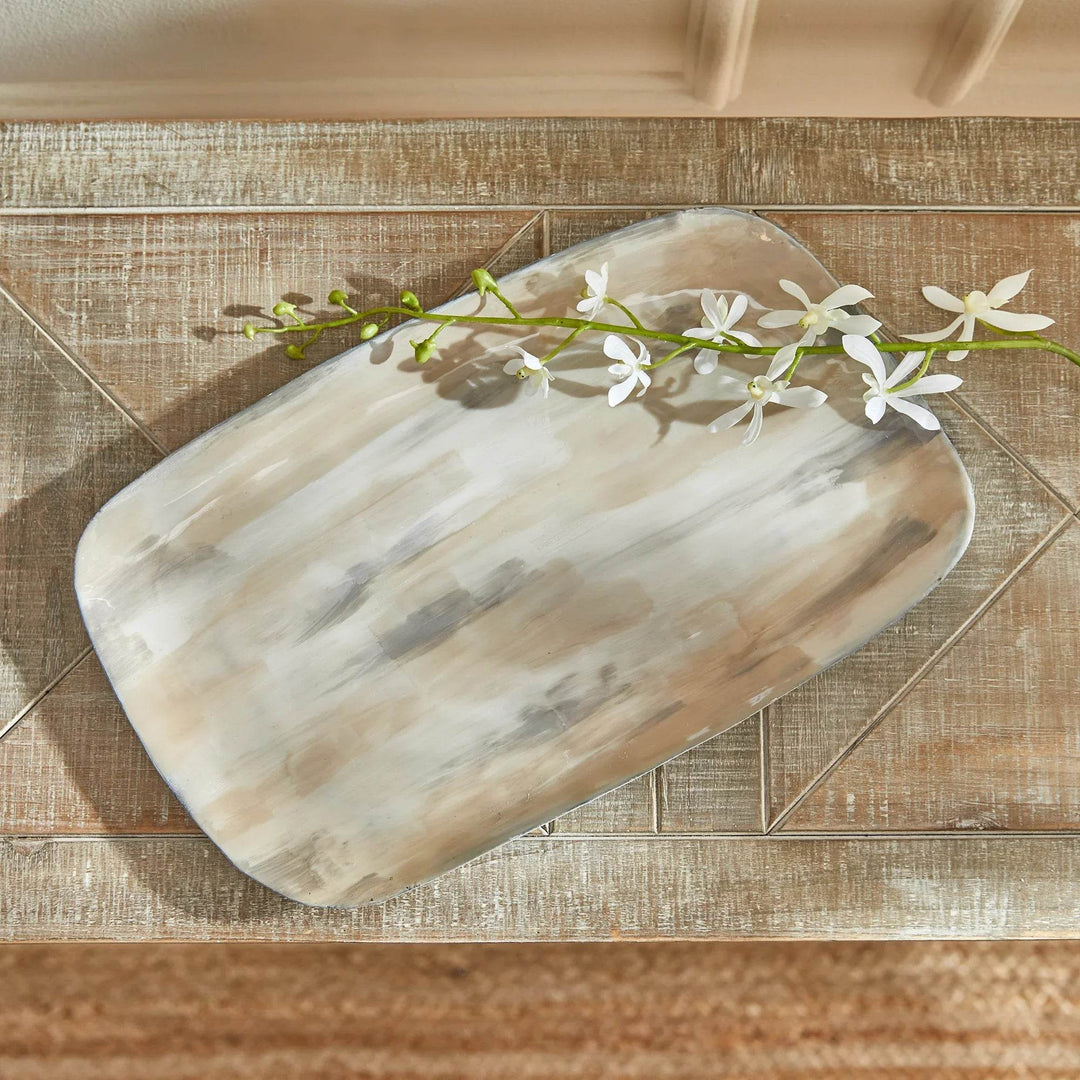 Cream enamel decorative tray with soft neutral brushstrokes styled with white florals on a wood surface – Modern Organic.

