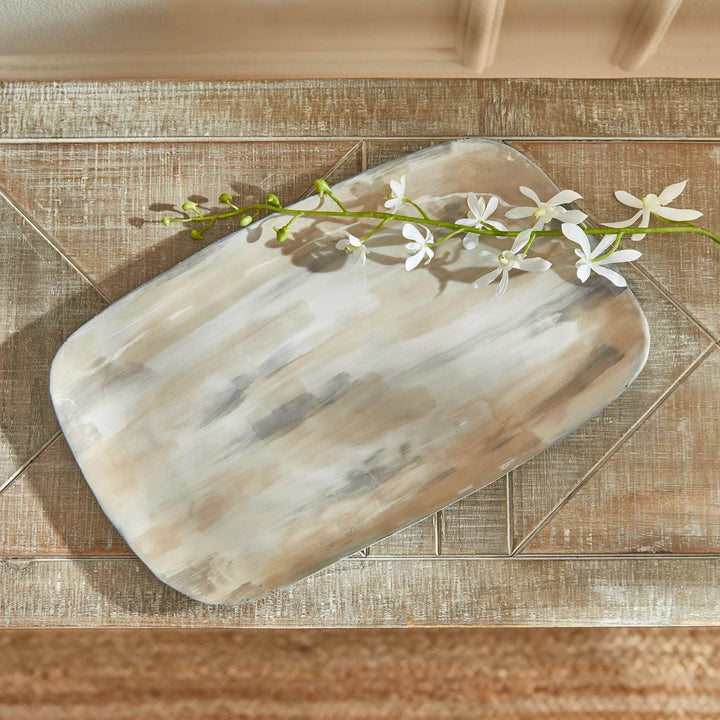 Cream enamel decorative tray with soft neutral brushstrokes styled with white florals on a wood surface – Modern Organic.

