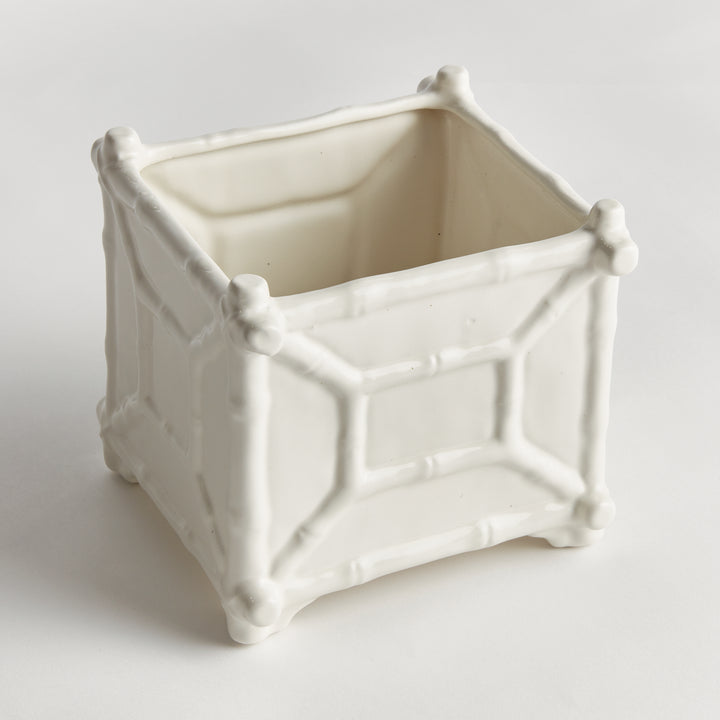 Large white ceramic cachepot viewed at an angle, with raised bamboo-inspired framing around the square body | Traditional