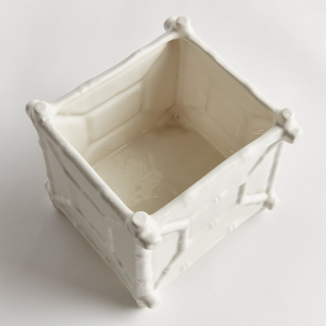 Top view into a large square white ceramic cachepot, showing its pale interior and raised bamboo-like corners | Traditional