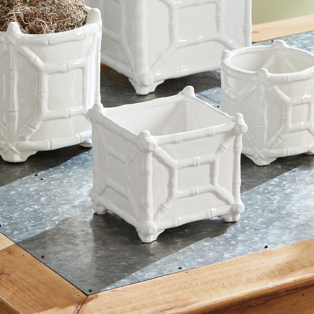 Small white bamboo-detail ceramic cachepot displayed with coordinating white vessels on a tray and tabletop | Traditional
