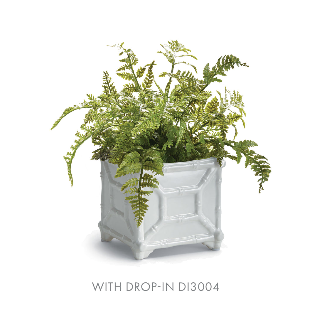 Small white bamboo-detail ceramic cachepot styled with a spreading faux fern, pictured against a white backdrop | Traditional