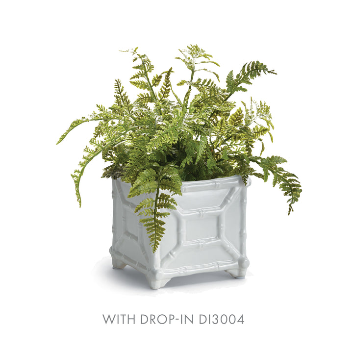 Small white bamboo-detail ceramic cachepot styled with a spreading faux fern, pictured against a white backdrop | Traditional