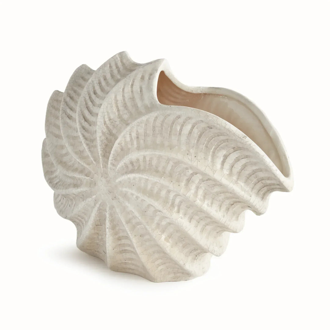 Cream clay shell vase with a spiraling sculptural body, raised ridges and an open mouth, in antique crackle glaze. Coastal