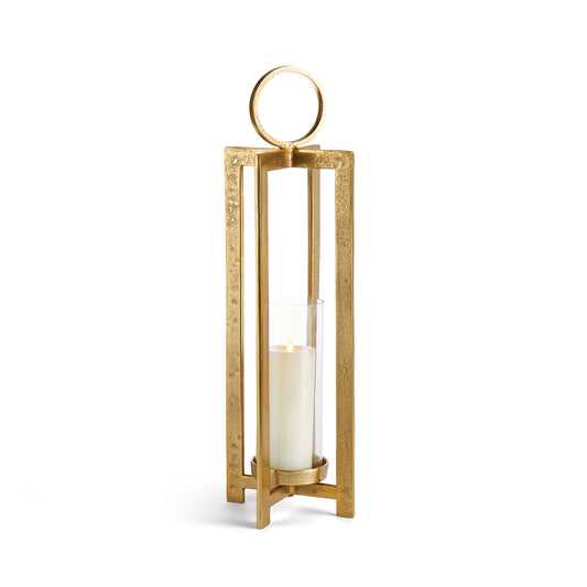 Elevate your space with the Asola Gold Hurricane Lantern Small. Exuding modern sophistication, this lantern boasts a striking form and impressive scale. With a footed detail that showcases your candle in style and a large round handle for effortless transportation, it's the perfect addition to mantles, front entries, and any other area in need of a touch of elegance.