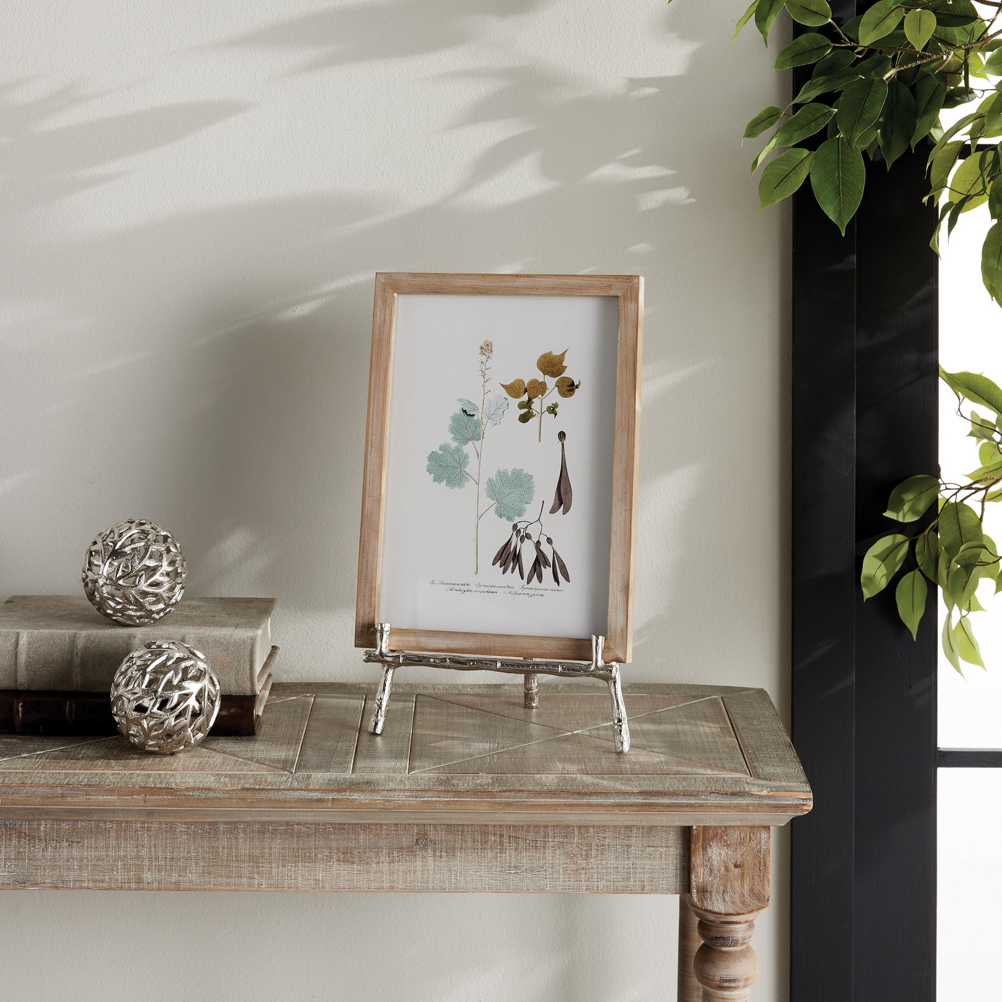 Elevate your decor with this sturdy and resilient silver easel, expertly crafted to exhibit platters, cookbooks, or small art pieces. The traditional aesthetic of bamboo-like silver details adds a timeless charm, while the versatile design allows for effortless display of various items.