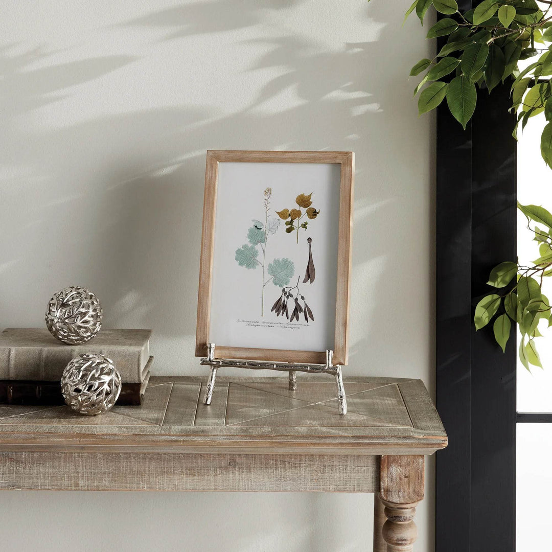 Elevate your decor with this sturdy and resilient silver easel, expertly crafted to exhibit platters, cookbooks, or small art pieces. The traditional aesthetic of bamboo-like silver details adds a timeless charm, while the versatile design allows for effortless display of various items.