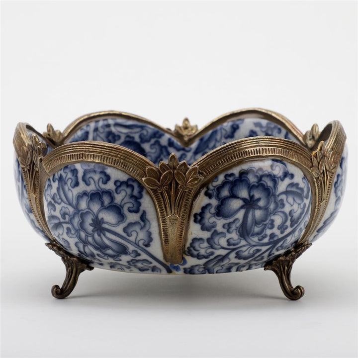 Blue and white floral porcelain bowl with bronze detailing displayed on glass shelf – Transitional