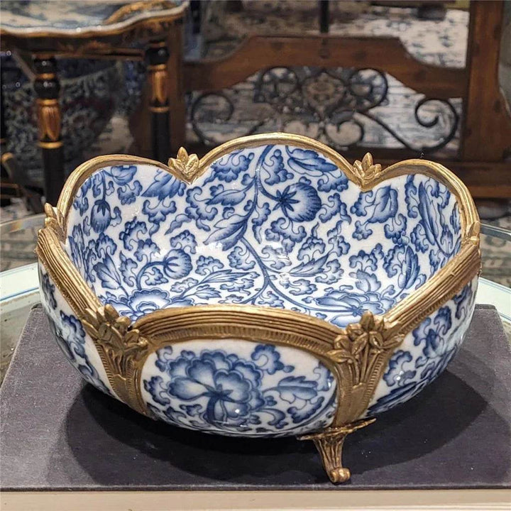 Blue and white porcelain bowl with bronze details styled on console table – Transitional