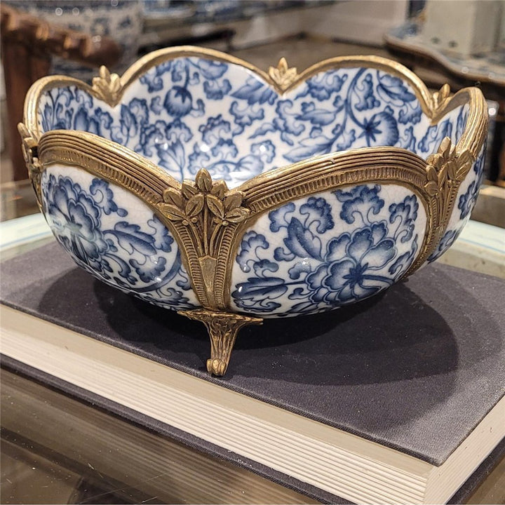Ornamental porcelain bowl with floral motif and bronze details viewed from side angle – Transitional