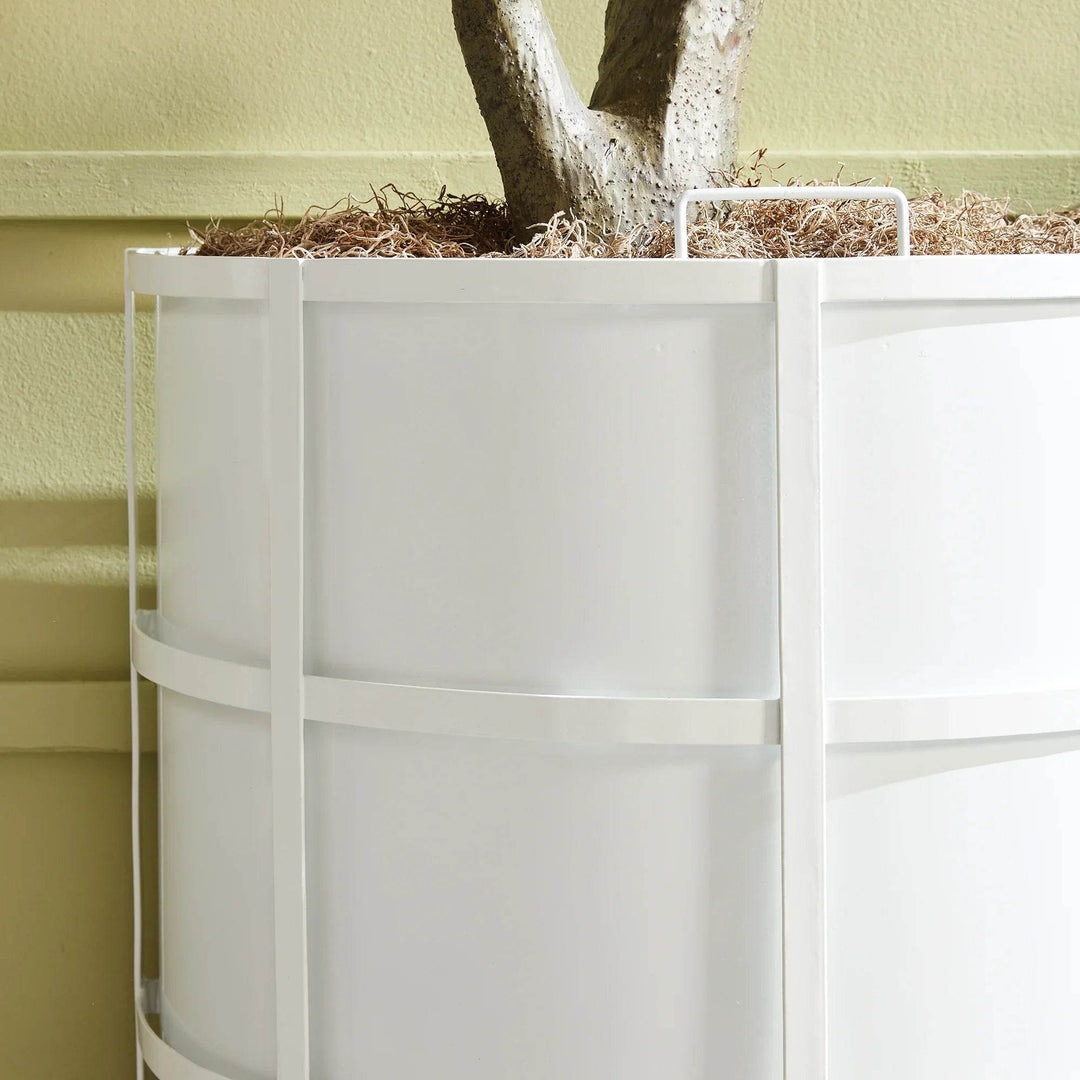 Closeup of white powder-coated planter with curved iron frame, ideal for transitional garden or patio spaces.