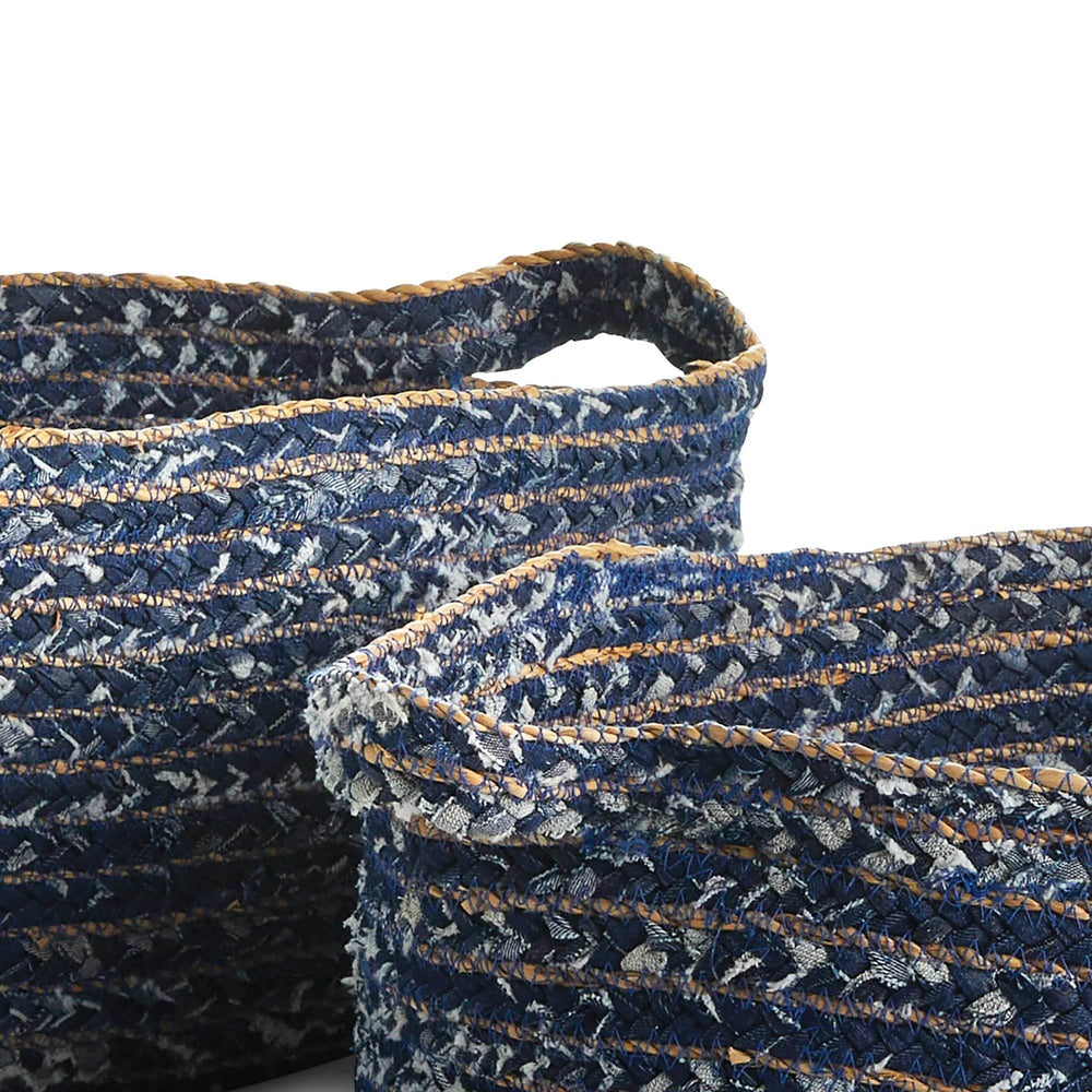 Closeup of recycled denim woven texture and handles on oval storage baskets, showing deep blue and natural seagrass details.

