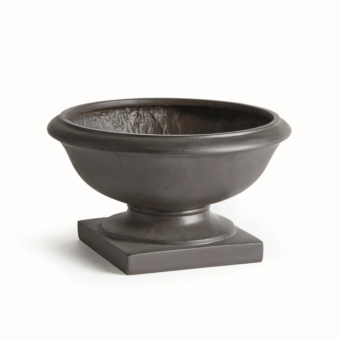 Antique black composite footed bowl planter with a round rim, curved basin and square base for a formal display. Transitional