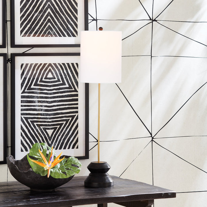 This tall, narrow lamp features a geometric turned wood black wash base, making it ideal for placement on either side of a long console or entry table. With its sleek and straightforward design, it provides a lovely way to illuminate a room with its soft light and black and gold accents, complemented by a linen shade.