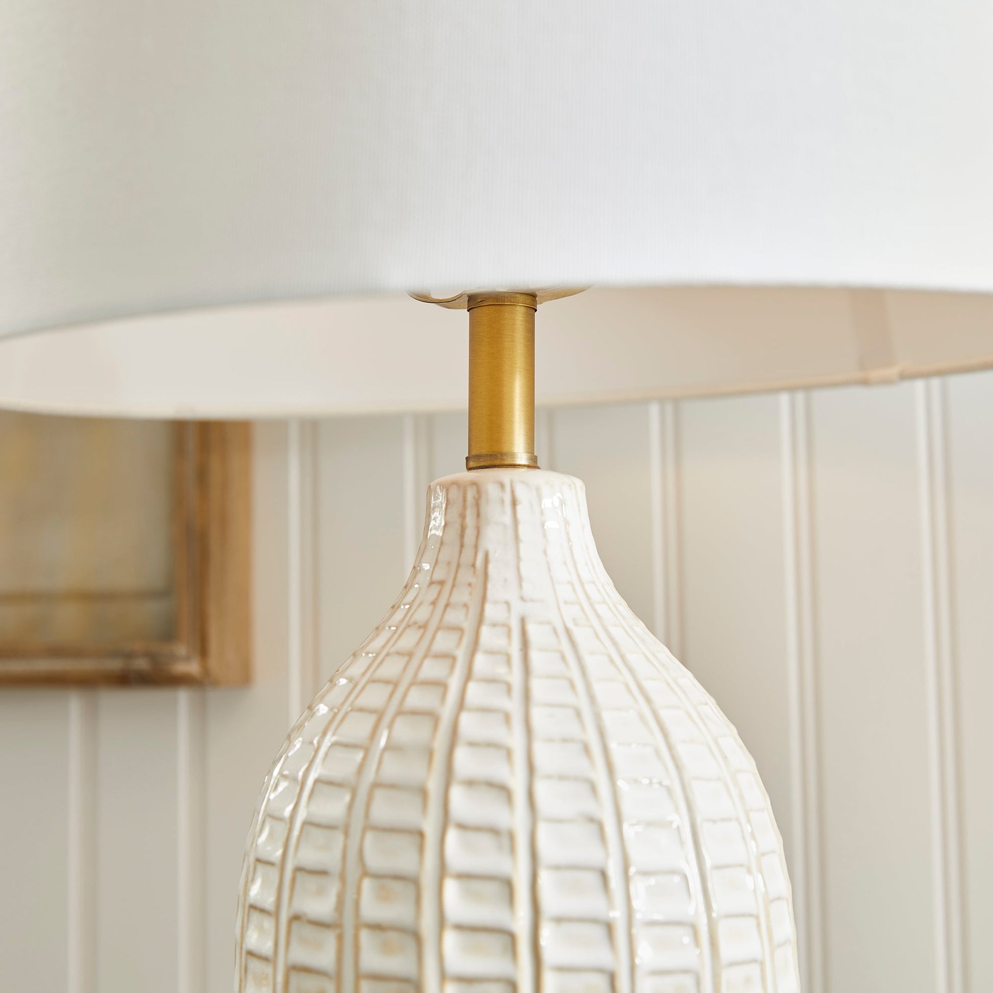 With a pressed pattern on the ceramic body, the Nadia Lamp is a work of art. Topped off with a generously scaled fabric shade, it is sure to enhance any space. intricate details, bold, finial, classic white, metal accents This ceramic lamp boasts an eye-catching pressed pattern and an elegantly designed fabric shade, making it an artistic addition to any room. With intricate details, a bold finial, and classic white coloring with metal accents, it offers both style and subtlety.