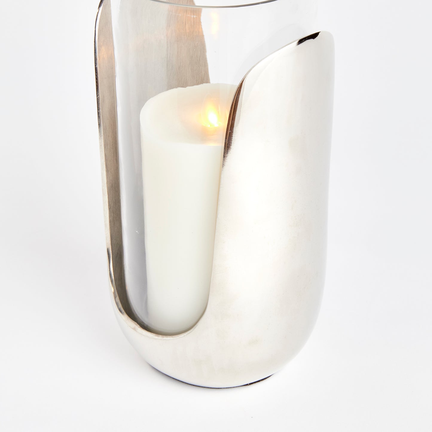 This hurricane boasts a stylish combination of hand blown glass and cast aluminum in a sleek silver design. The glass slides into the abstract base, adding a touch of thoughtfully crafted design to any side table, console, or mantel. Made with high-quality materials, this functional and beautiful hurricane is a must-have for any room. Elevate your decor with this one-of-a-kind contemporary accent piece.