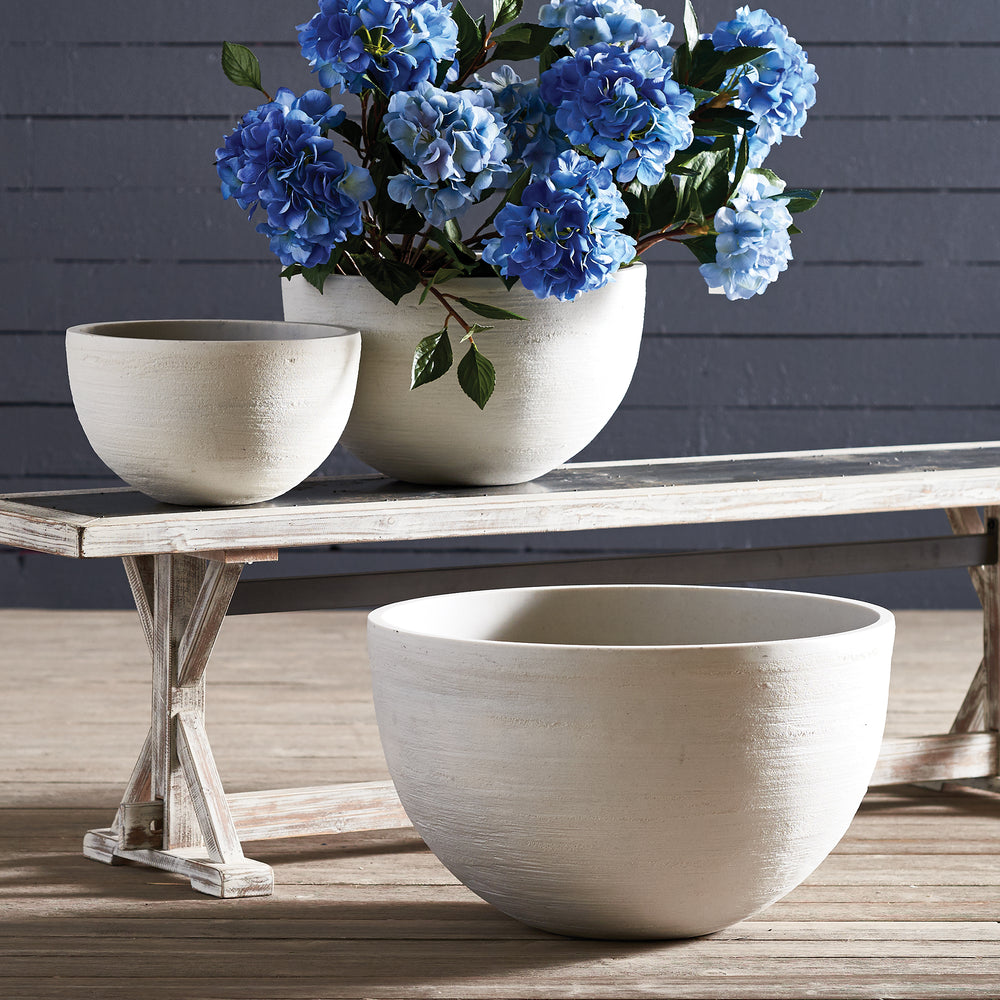 White bowl planters arranged beside a rustic wooden bench, with blue hydrangeas in one of the three pots - Modern Organic