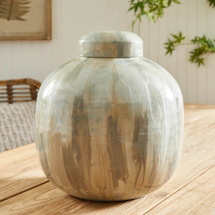 Close view of hand-painted enameled iron lidded urn highlighting tone-on-tone brushwork and gentle gloss across the curved surface – Transitional