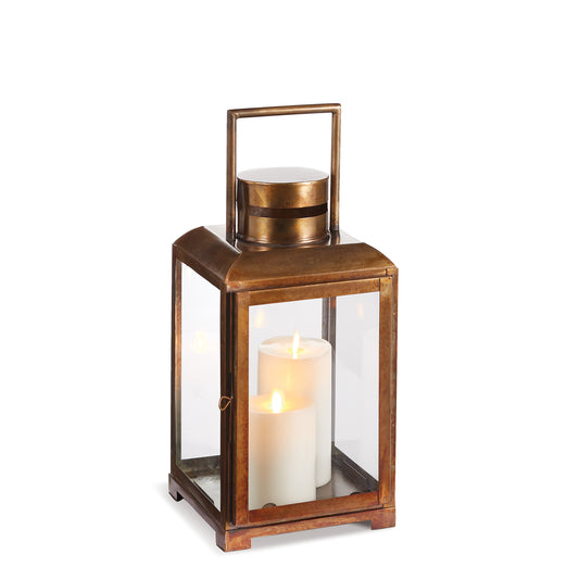 This lantern features a warm antique brass construction, classic lines, and a simple design. It is equipped with large clear glass panels, allowing the candlelight to illuminate the evening. Bring timeless elegance into your home with this lantern. Its clean design and antique brass construction add a sophisticated touch to any space. Additionally, the large glass panels provide a cozy ambiance as they let the warm glow of candlelight fill your evenings.