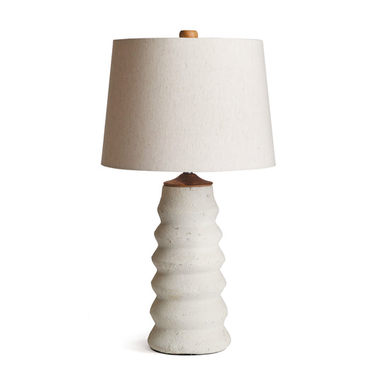 Made of a composite, natural eco-mix, the Adria Lamp Base is composed of hardening agents for longevity. The finish is warm white with a pitted texture that shows the softness of the material. With a tapered shade, and neutral tone, works well in every environment.