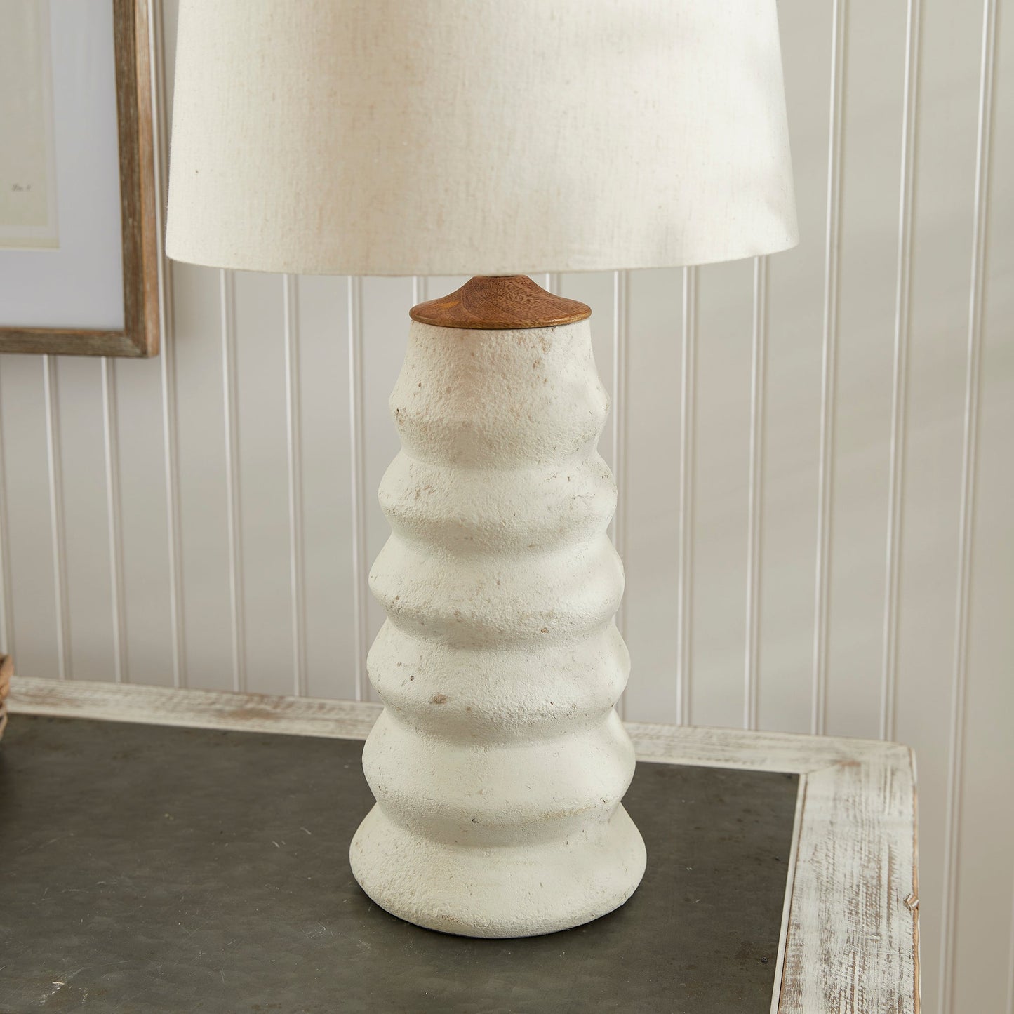 Enhance your living area with the Adria Table Lamp. This elegant table lamp features a natural cream eco-mix with a unique pitted texture, creating a lasting and warm white glow. The tapered shade adds a touch of sophistication to any living room.