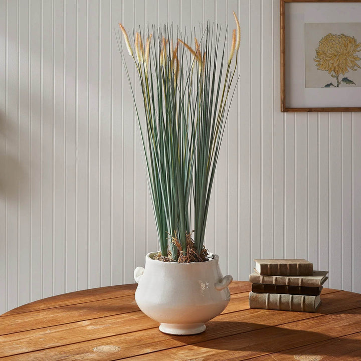 Faux field grass drop-in styled on a wooden table in a white pot, showcasing lifelike green blades with golden tips – Modern Organic.

