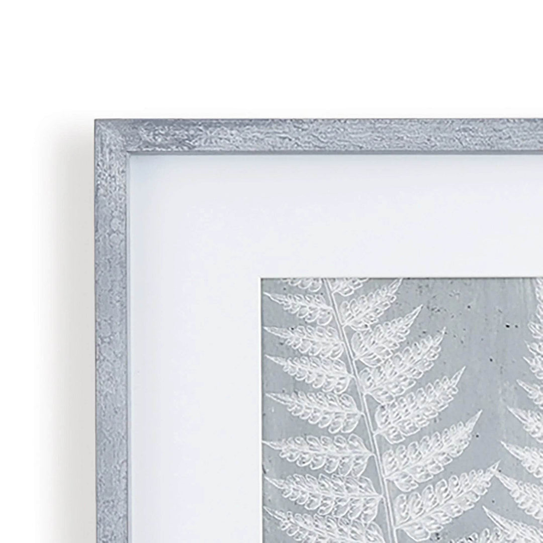 Close-up of gray frame and fern print detail showing wood grain texture and clean white mat.