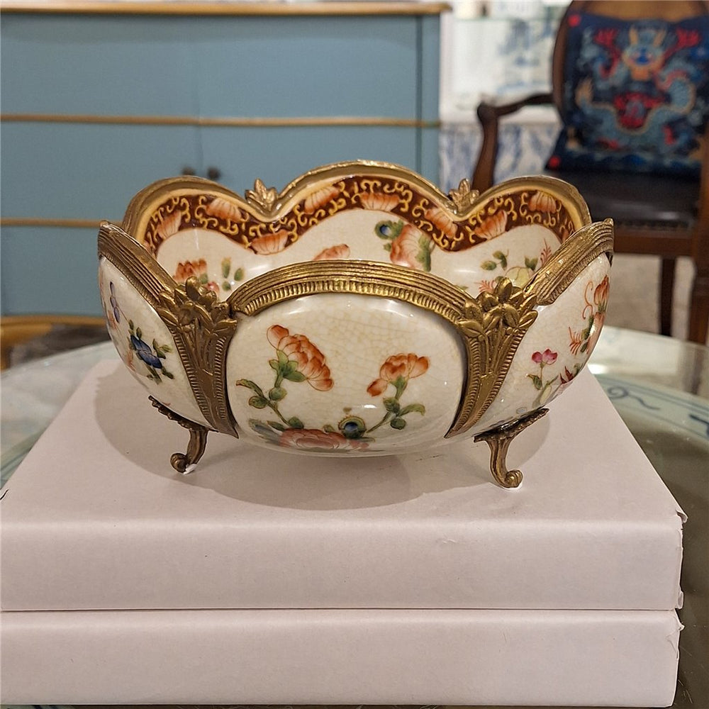 Floral porcelain decorative bowl with ornate bronze ormolu feet and scalloped edges styled in a collected interior – Traditional style