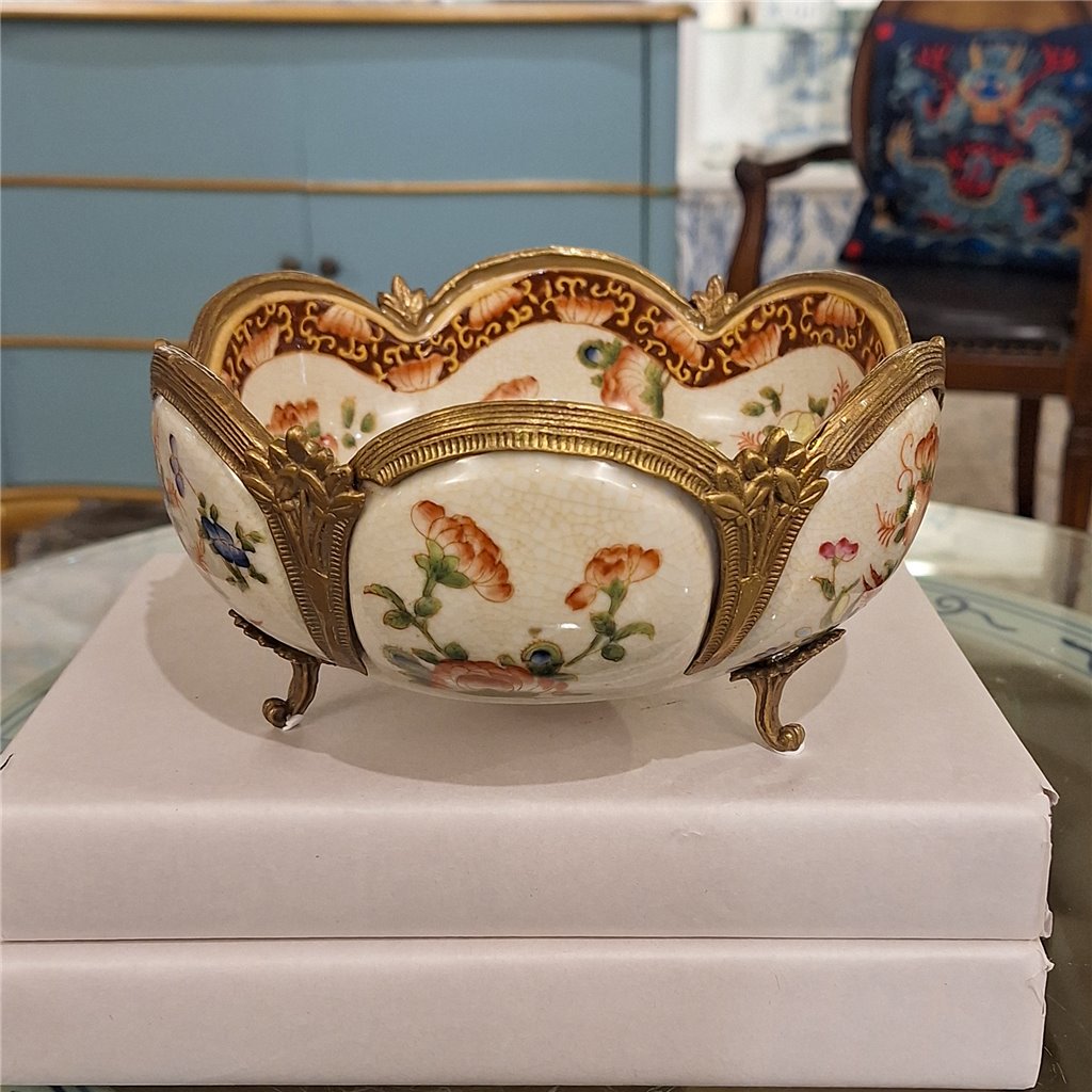 Floral porcelain decorative bowl with ornate bronze ormolu feet and scalloped edges styled in a collected interior – Traditional style