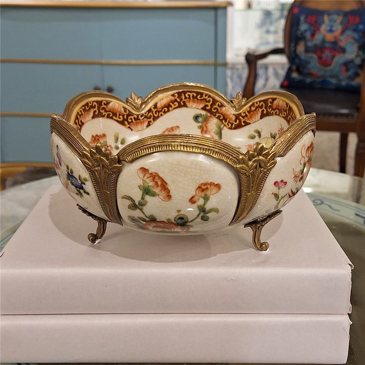 Floral porcelain decorative bowl with ornate bronze ormolu feet and scalloped edges styled in a collected interior – Traditional style
