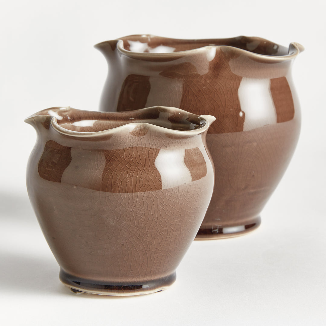 Brown ceramic pot pair shown at an angle, with ruffled rims, rounded bodies and a reflective reactive glaze. Transitional