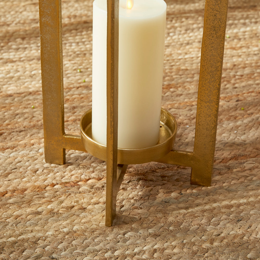 Close view of antique gold geometric metal lantern raised candle platform and base detail with pillar candle, Transitional style
