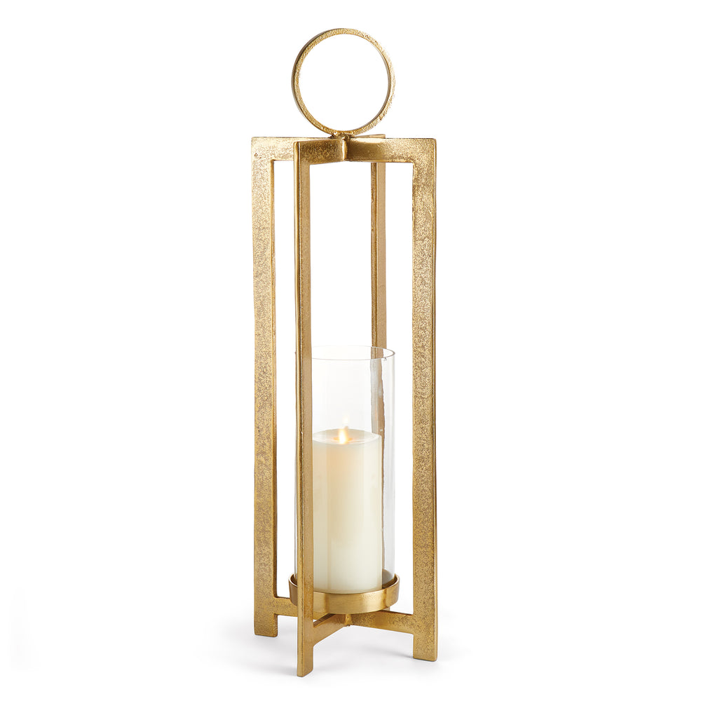 Large antique gold geometric metal lantern with clear glass hurricane insert and ring handle on white background, sculptural candle lantern Transitional style
