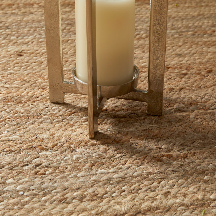 Small antique gold geometric metal lantern with glass hurricane styled on floor beside chair, decorative lantern Transitional style
