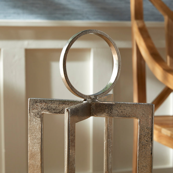 Close view of antique silver geometric metal lantern ring handle and upper frame with wood shelf background, Transitional style
