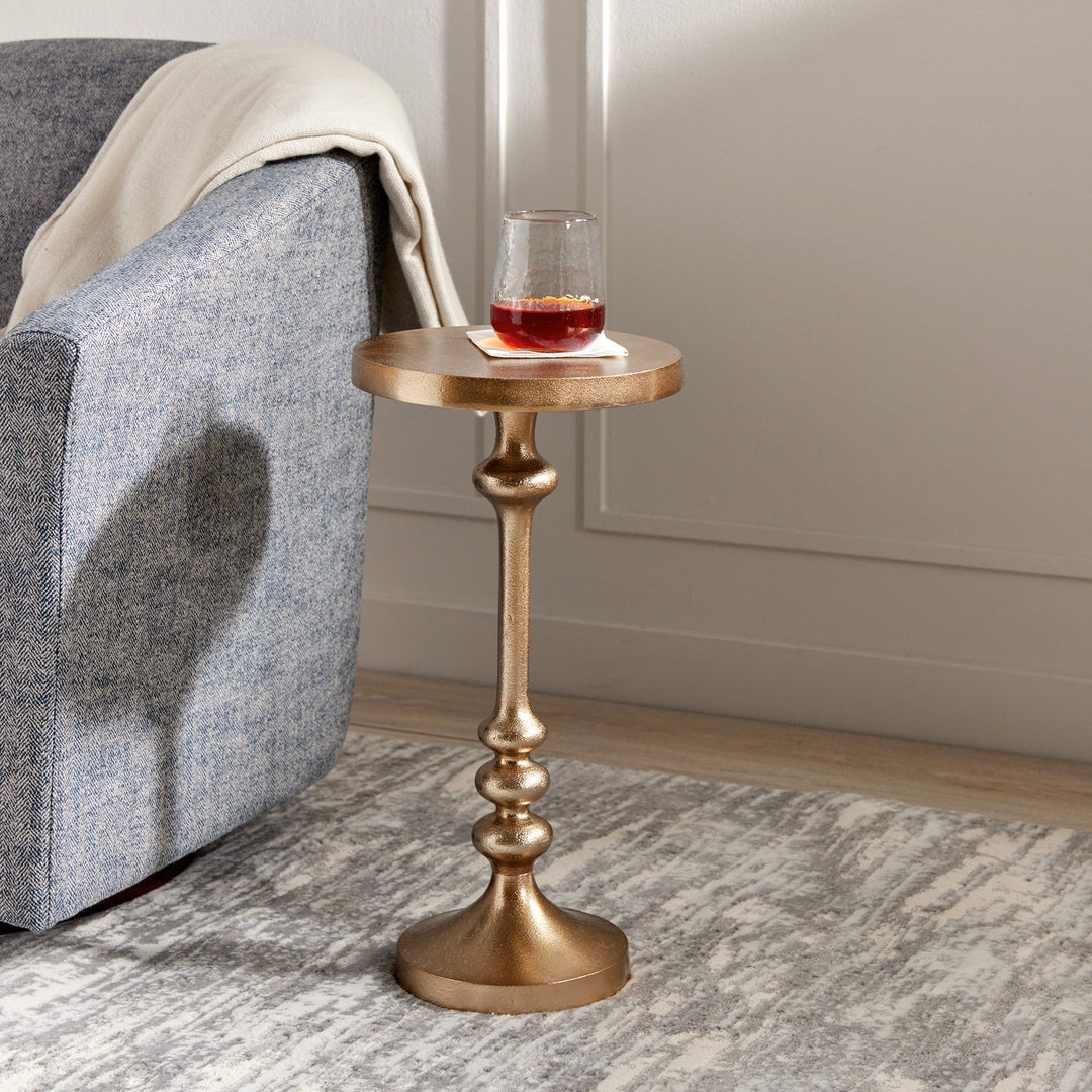 Slim brass drink table with glassware staged in modern glam living space.

