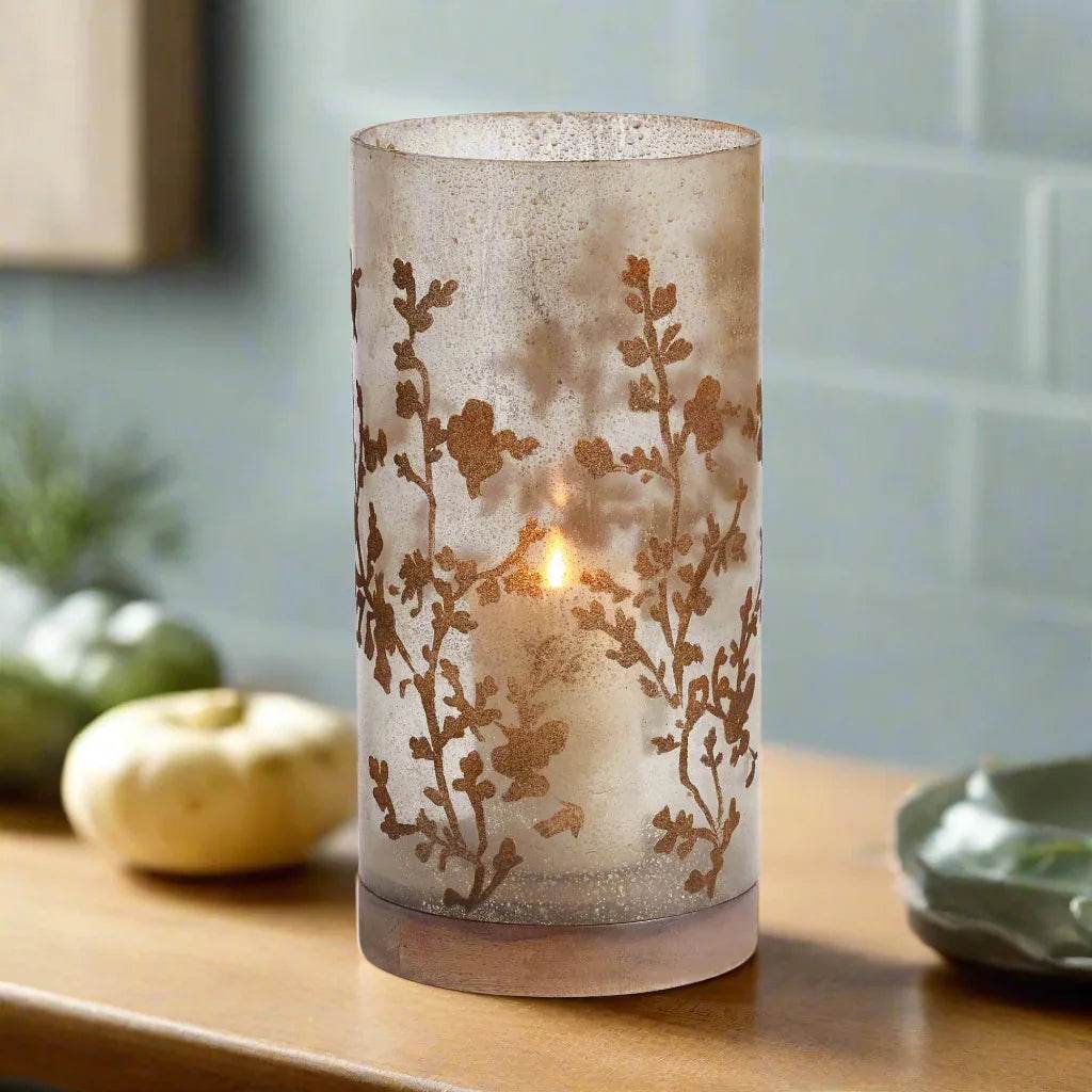 Medium glass hurricane candle holder with antique vine etching and wood base, styled on a tabletop – Modern Natural style