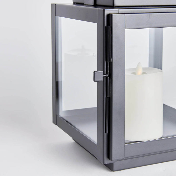 Detail of glass panel and door on small black lantern