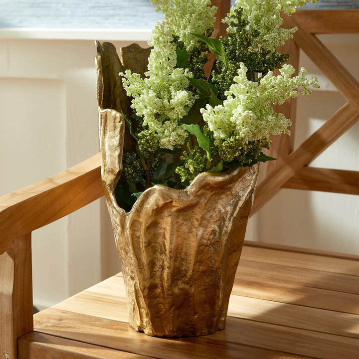 Gold aluminum vase with organic textured rim, styled with green floral stems on wood chair, decorative interior accent – Organic Modern.