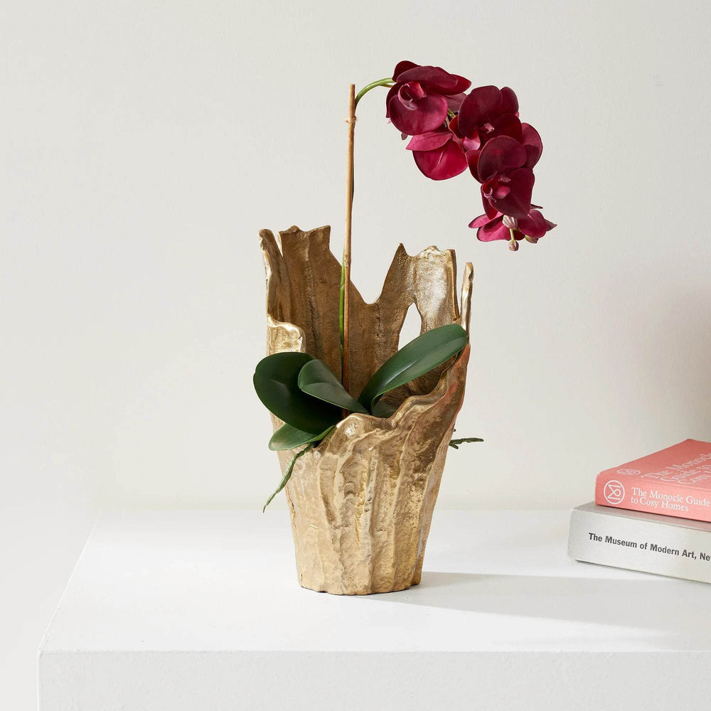 Gold aluminum vase with organic sculptural rim, styled with orchid plant on stacked books, decorative accent for interiors – Organic Modern.