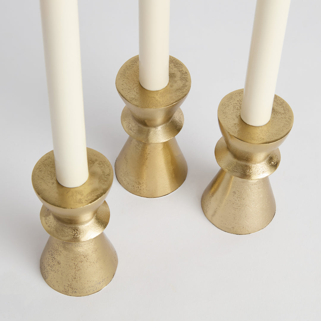 Top-down view of gold aluminum taper holders highlighting cast surface detail and warm reflective finish – Transitional