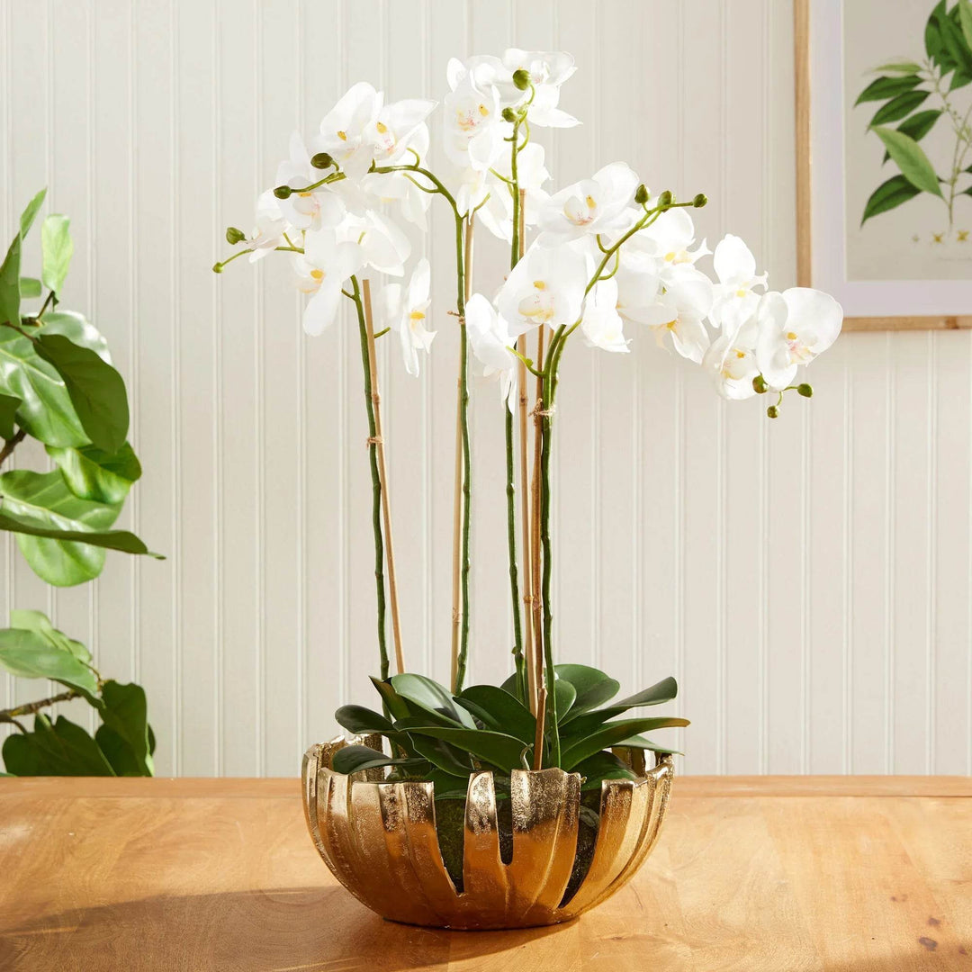 Gold decorative metal bowl used with white orchid drop-in arrangement, modern centerpiece for dining or kitchen table.

