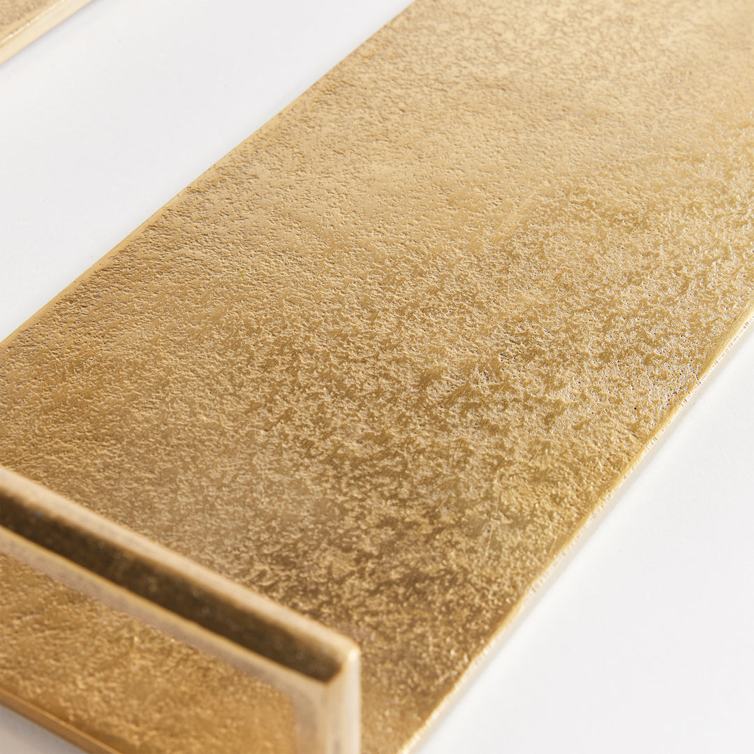 Close-up of textured gold cast aluminum decorative tray surface finish with raised rectangular handle detail – Transitional.